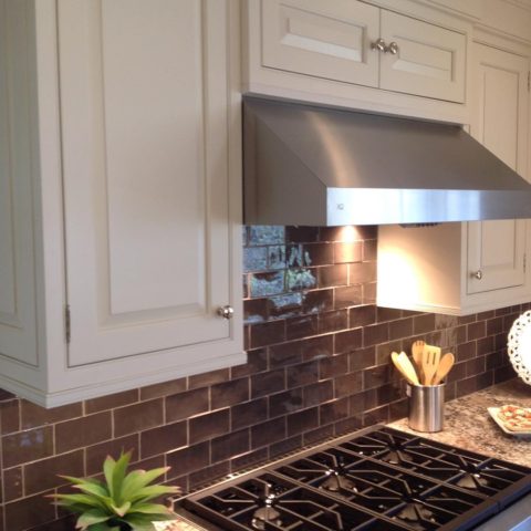 Dark subway tile is a nice contrast to our client's white painted cabinetry and stainless appliances. #warmkitchen #insetcabinets #subwaytile #designnj #newjerseykitchenandbath #kitchendesign #njkitchens #whitekitchen #stainlessappliances