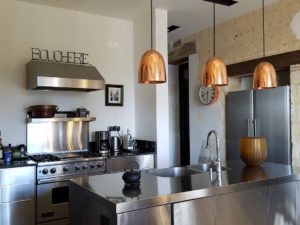 French designed gourmet kitchen in our France Chateau! #vacationviews #stainlesskitchen #stainlesscabinets #stainlesscounters #stainlesskitchenisland #designnj #njkitchenandbathdesign #copperpendantlights