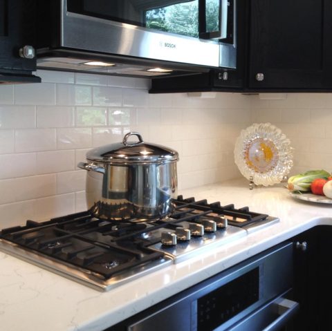 Our client's clean and simply beautiful subway tile backsplash! #whitesubwaytile #boschmicrowave #boschhoods #quartzcountertops #shakercabinets