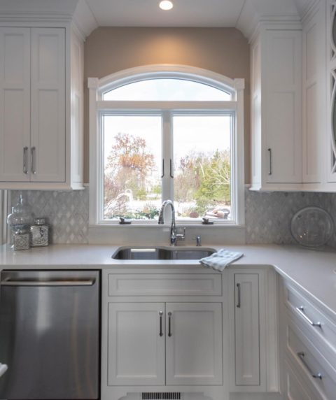 Arched window provides a beautiful view in our client's new kitchen! #kitchenwindow #designnj #njkitchens #newjerseykitchensdesign #undermountsink #whitekitchen #archedwindow #stainlessappliances