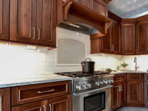 Walnut cabinets, tin ceiling tiles, chevron patterned floor tiles, stainless appliances and a custom wood hood create one beautiful kitchen!
#njdesign #newjerseykitchenandbath #designnj #njkitchen #walnutcabinets #customhood #stainlessappliances #chevronfloor #tinceiling